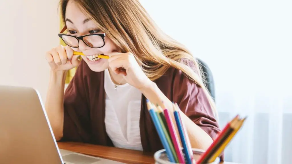 Educazione e metaverso - studentessa con matita in bocca davanti al computer.
